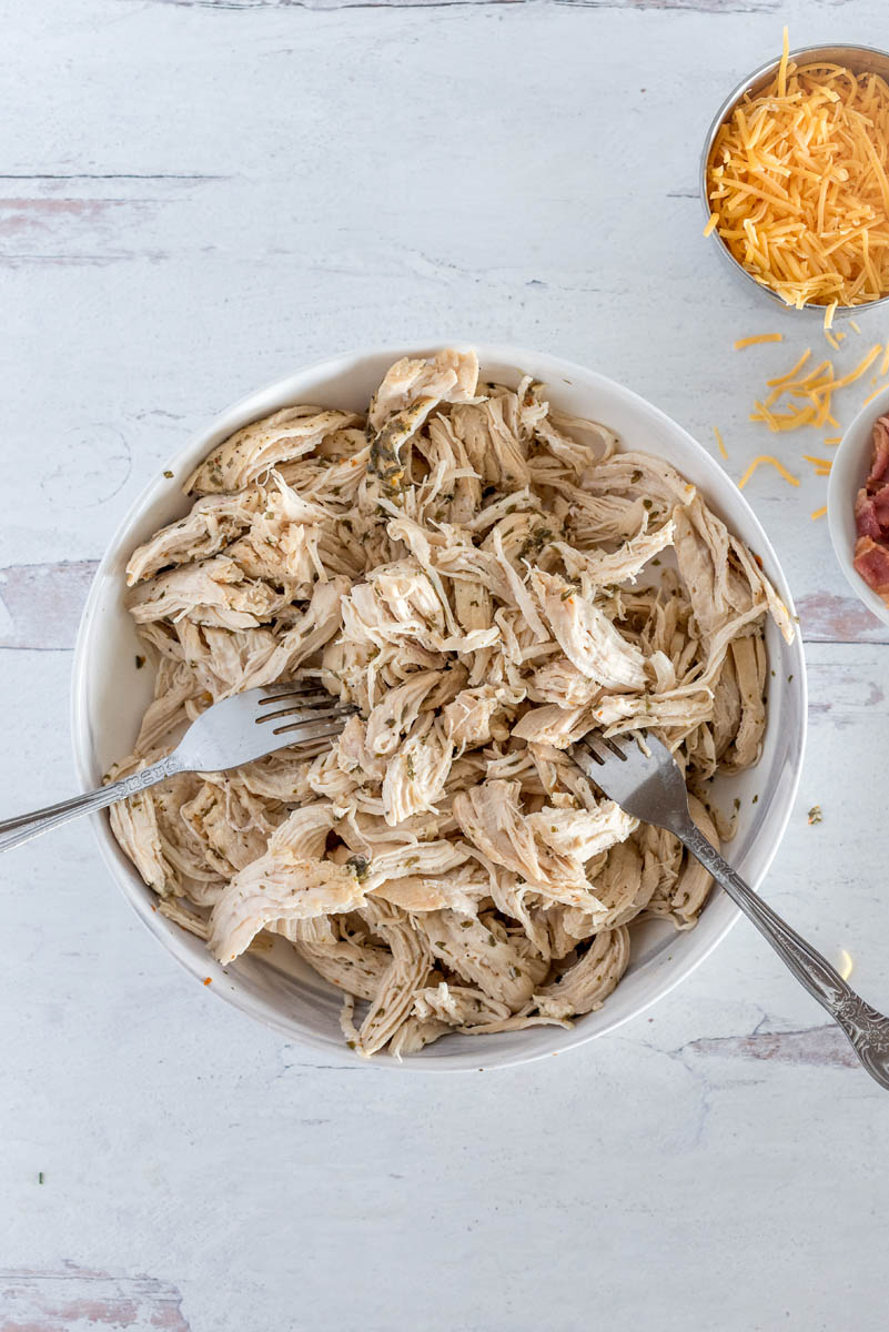 A bowl of shredded chicken for Instant Pot bacon ranch chicken