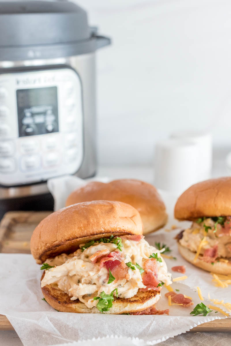Bacon chicken ranch sandwiches prepared and ready to serve sitting in front of an Instant Pot.
