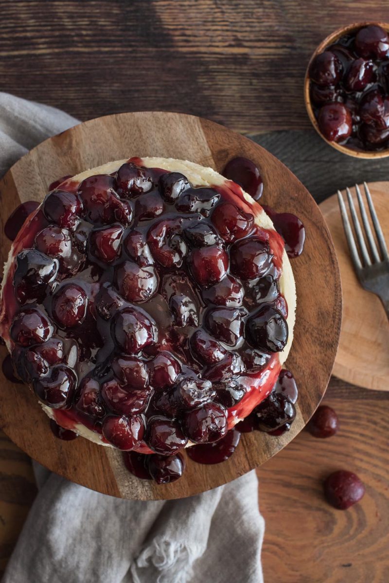 Overhead picture of an Instant Pot black forest cheesecake on a wooden serving plate.