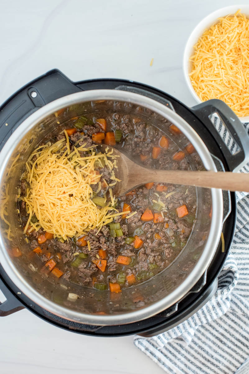 Adding cheese to the cheeseburger soup cooked in an Instant Pot