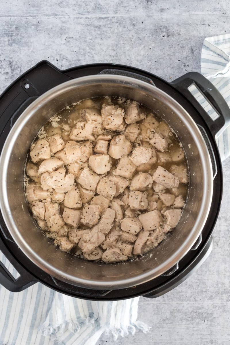 Diced chicken cooked in an Instant Pot and ready to be divided for chicken salad sandwiches, stacked enchiladas, and teriyaki bowls.
