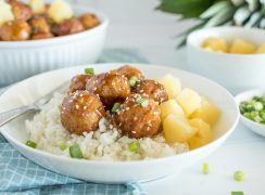 Close up picture of Instant Pot Hawaiian meatballs served over rice, and topped with sesame seats and green onions.