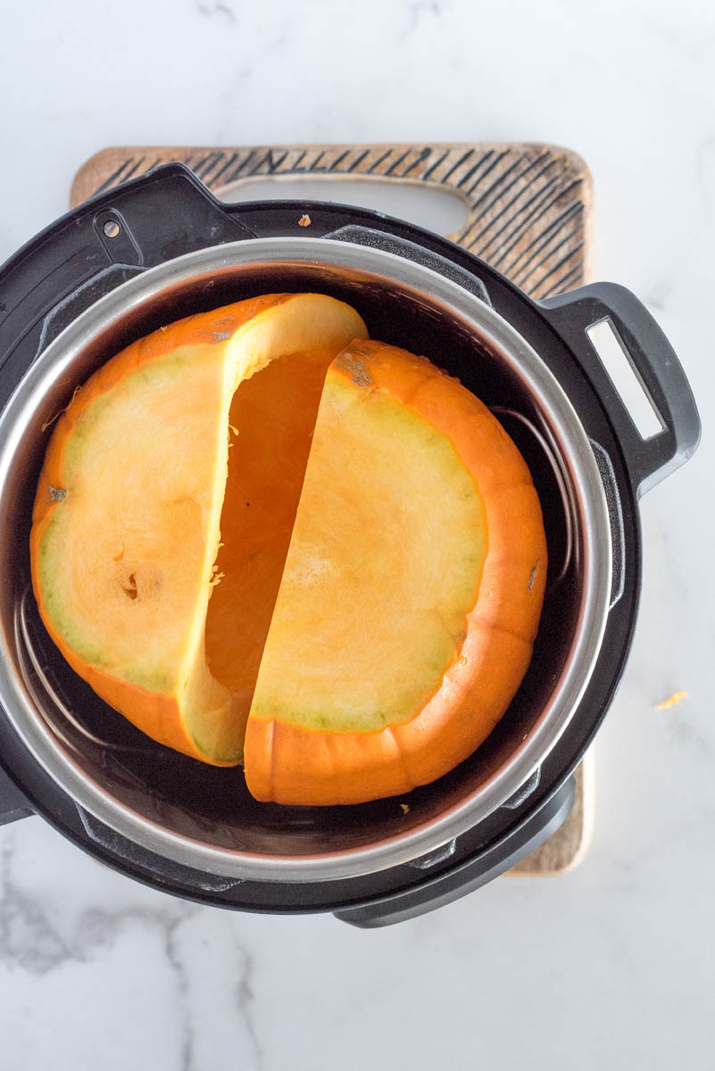 A pumpkin cut in half and cleaned out in an Instant Pot ready to cook.