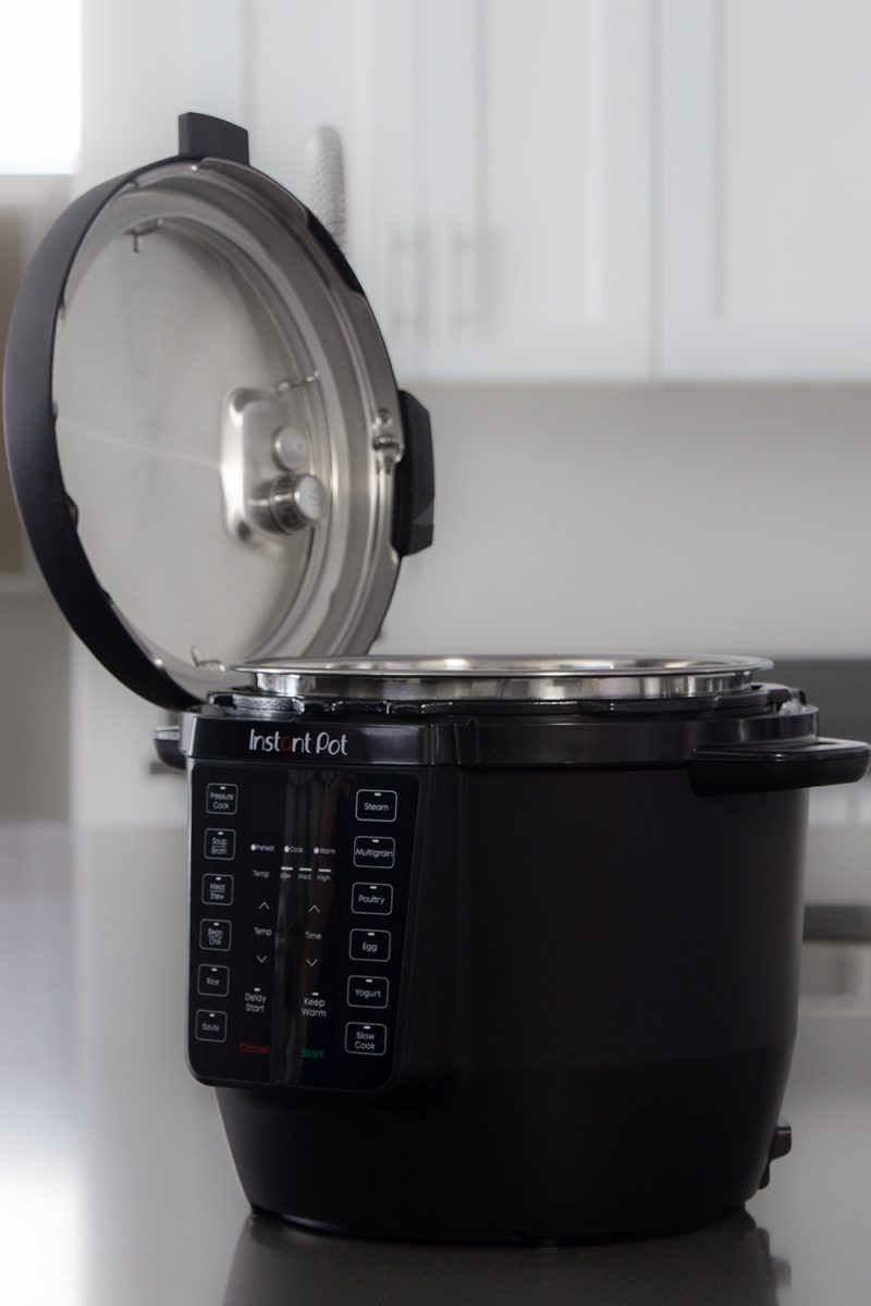 The Instant Pot Rio on a counter with the lid open and resting in the lid fin on the side of the pot.