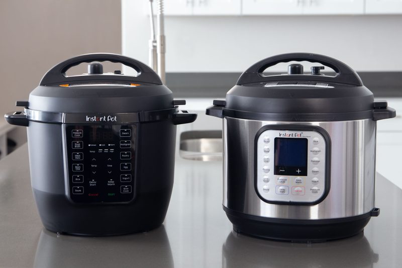 A side by side comparison of the Instant Pot Rio with the mat black exterior, next to the Instant Pot Nova with a stainless steel exterior.