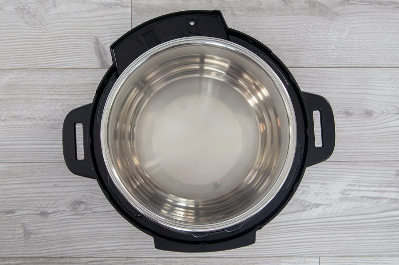 Overhead picture of an Instant Pot Rio with its lid off, revealing a stainless steel pot and black housing around the edge.
