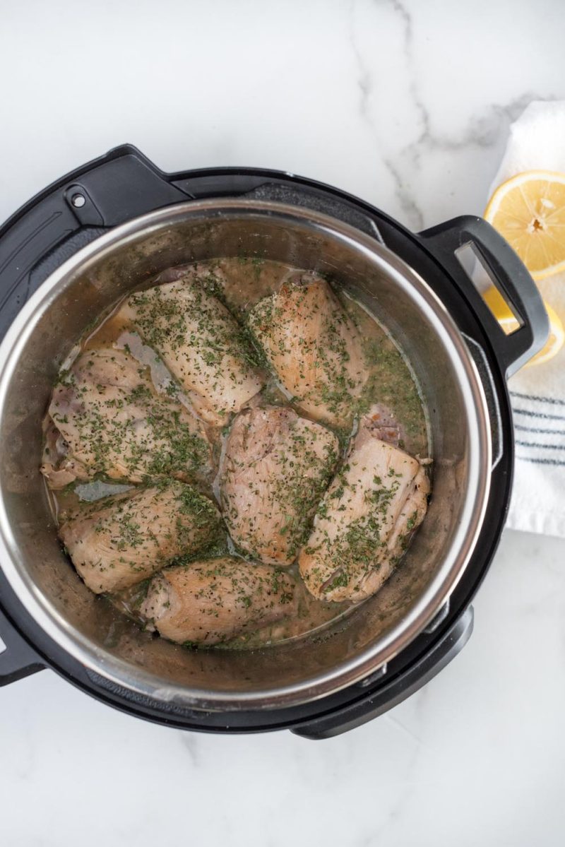 Overhead picture of cooked chicken thighs in an Instant Pot for making lemon basil chicken.