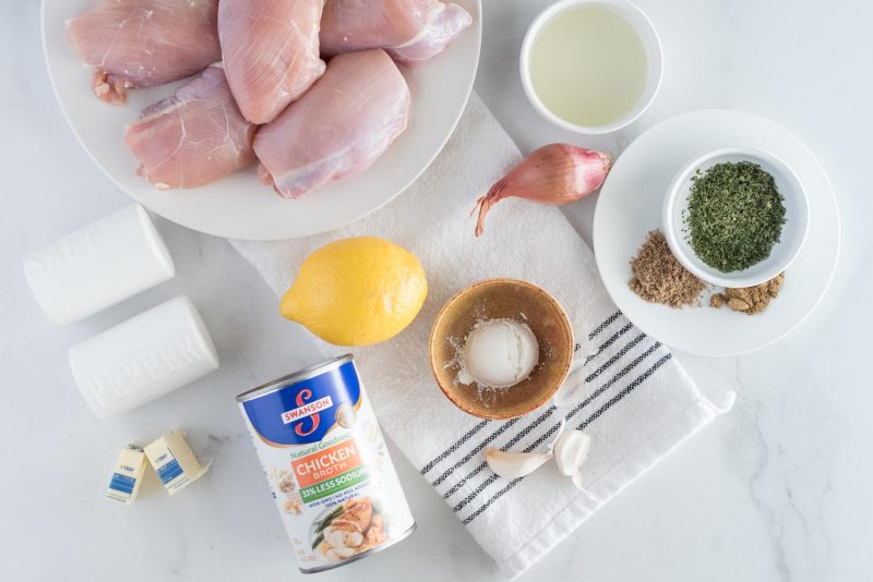 Ingredients for Instant Pot lemon basil chicken, including chicken thighs, lemon juice, spices, shallots, corn starch, garlic, a lemon, chicken broth, and butter.