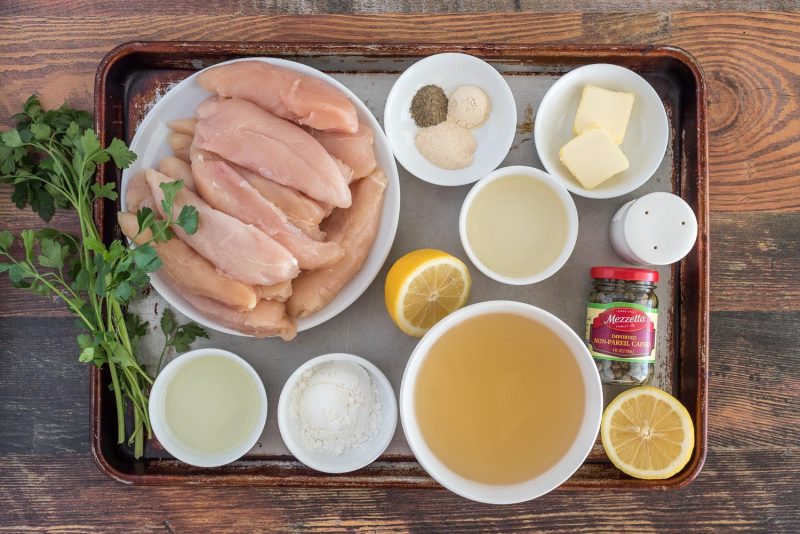 Ingredients for Instant Pot lemon chicken piccata, including chicken tenderloins, spices, white wine, butter, capers, lemon, chicken broth, corn starch, and lemon juice.