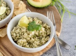 Instant Pot green salsa rice in a white bowl, with a lime wedge and fresh cilantro on top.