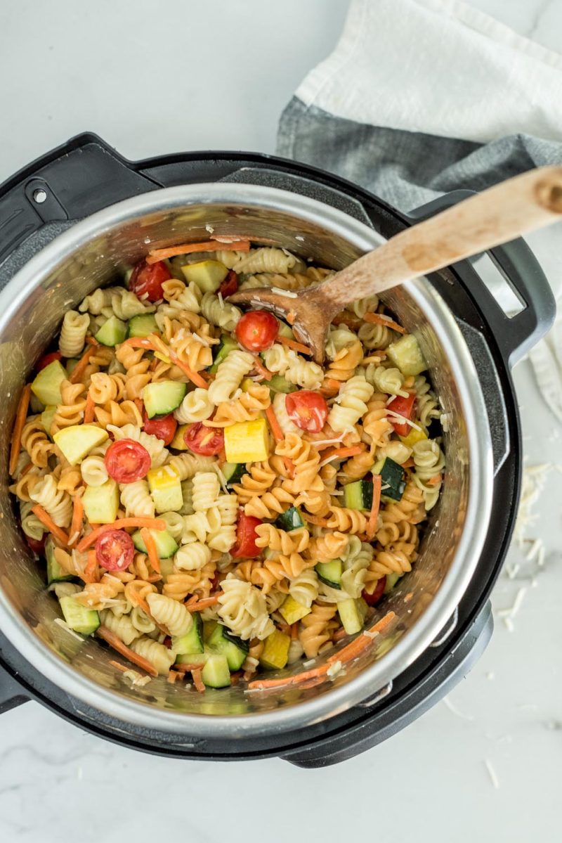 Overhead Picture of Instant Pot pasta salad with rotini, sliced cherry tomatoes, zucchini, cucumber, parmesan, and fresh parsley, all mixed and ready to serve from inside an Instant Pot.