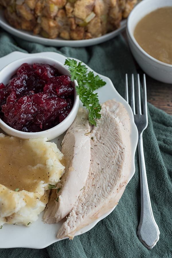 Instant Pot Thanksgiving meal, with all elements prepared in the pressure cooker including turkey, gravy, cranberry sauce, and stuffing (dressing)