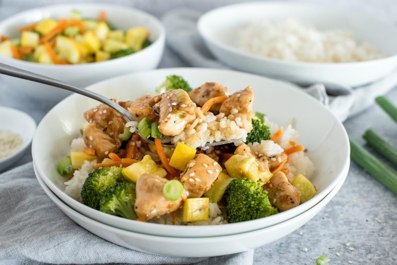 Close up of Instant Pot teriyaki bowls with broccoli, carrots, yellow squash, and green onions.
