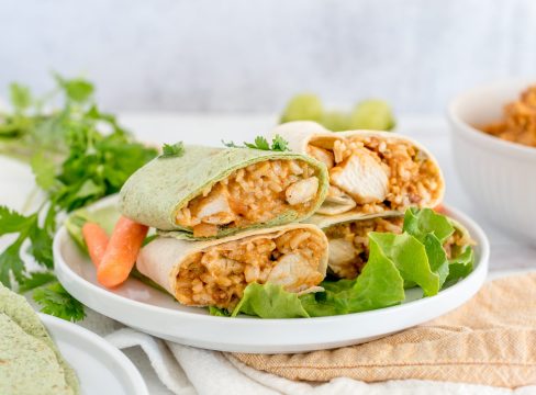 Instant Pot Thai chicken wraps stacked on a plate with lettuce and carrots