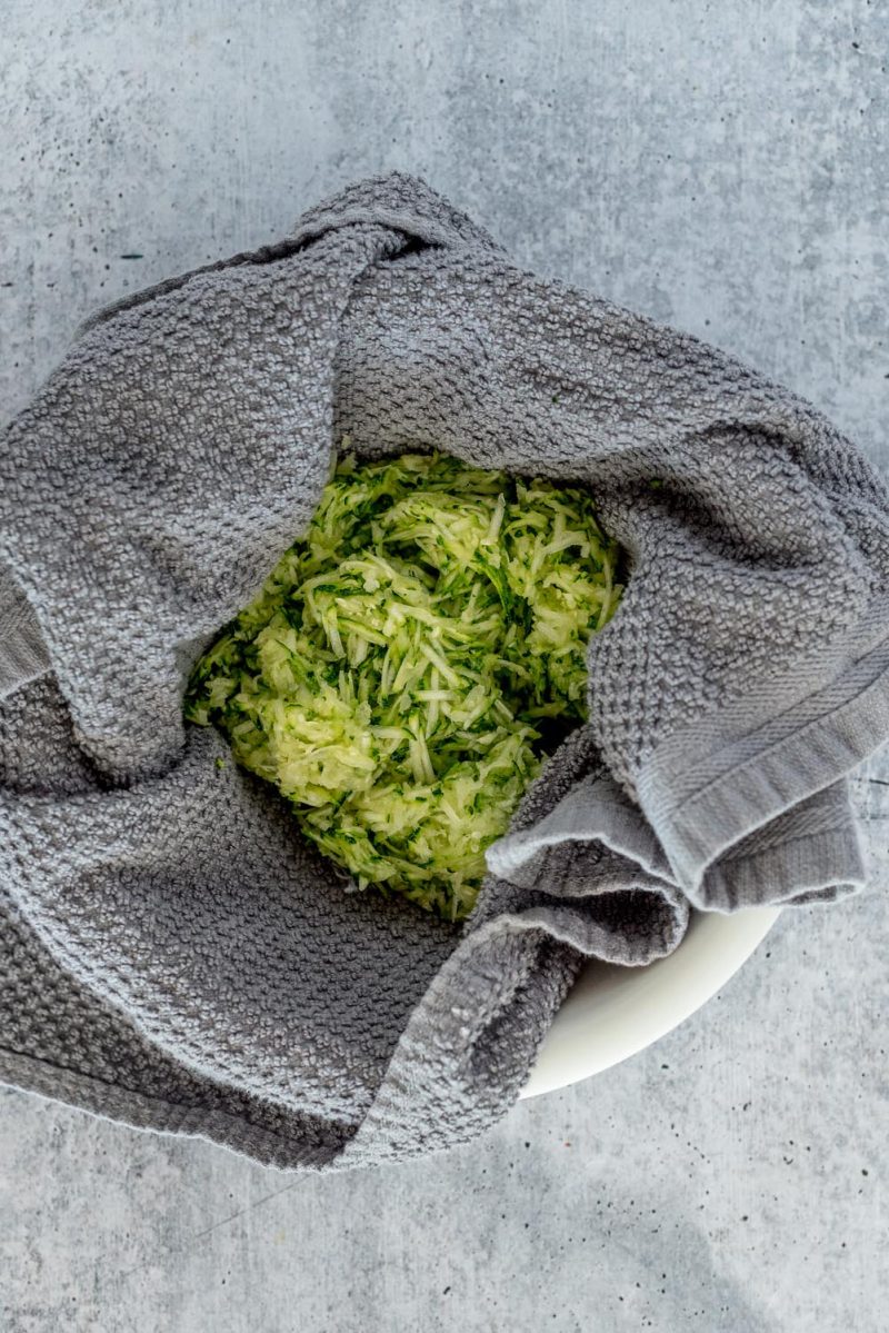 Placing shredded zucchini in a towel to drain off excess moister for making Instant Pot zucchini bread.
