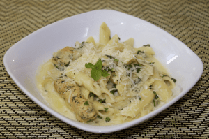 spinach-artichoke-pasta-with-chicken in a white bowl